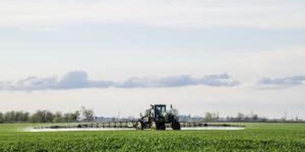 Tractor applying pesticide in field